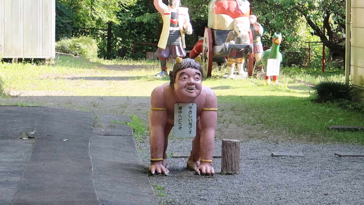 strange bending over demon statue momotaro shrine